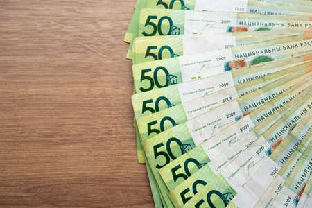 Belarusian paper money on wooden background. many colored currency of different denominations....
