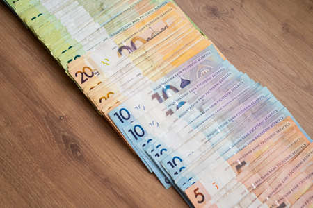 Belarusian paper money on wooden background. many colored currency of different denominations. Banknotes of the Republic of Belarus.の写真素材