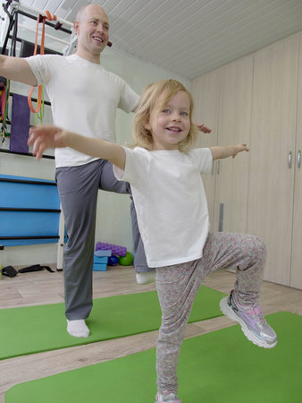 girl on physiotherapy in a children therapy center. Kid doing exercises training with physiotherapists. prevention and treatment of scoliosisの写真素材