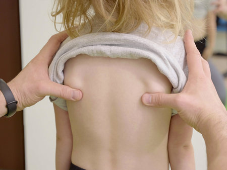 Physical Therapist checking child patient backs in health center. Children Posture Correction....