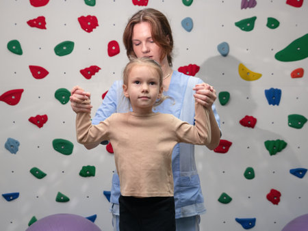 Physical therapist working with little girl in sensory room. Exercising for development of tactile sensations. Physiotherapy and neuro corrections in children therapy centerの写真素材