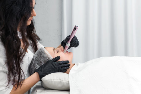 cosmetologist making mesotherapy injection with dermapen on face for rejuvenation. Anti-aging treatment and face lift in cosmetology clinic. medical procedure with Electric pen. banner with copy spaceの写真素材