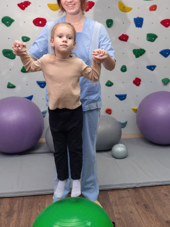 Physical therapist working with little girl in sensory room. Exercising for development of tactile sensations. Physiotherapy and neuro corrections in children therapy centerの写真素材