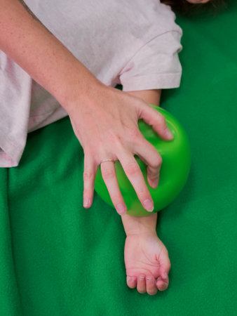 Physical therapist working with little girl in sensory room. Exercising with weighted ball and pressure to help kid relax in a therapy center. sensory integration sessionの写真素材