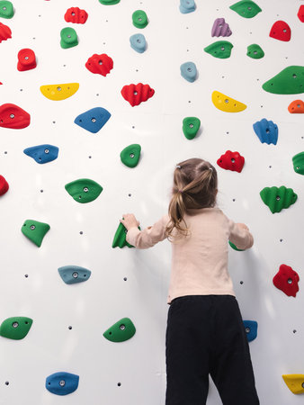 Physical therapist working with little girl in climbing wall. sensory integration room. Physiotherapy and neuro corrections in children therapy centerの写真素材