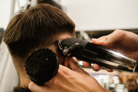 Barbershop. Unrecognizable male barber hands making customer Fashionable haircut in Modern style...