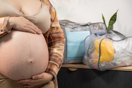 Pregnant woman stroke big belly and collects a bag in the hospital at home. Future mom at 9 months...