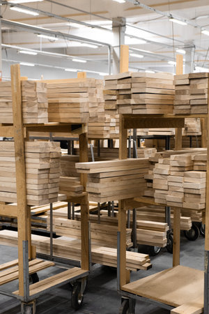 Wooden planks are neatly stacked on carts in a warehouse setting. Concept of lumber, construction materials, or resource management is conveyed.の写真素材