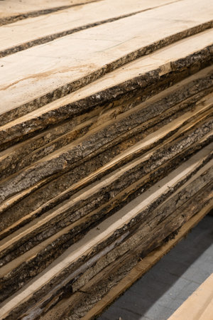 Stacked lumber displays a textured, rustic aesthetic. Concept of natural resources, woodworking, or...