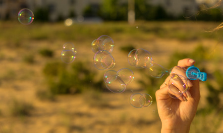 Bubbles at the sky, romantic inflating colorful soap bubbles in parkの写真素材