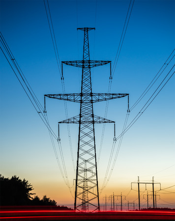 High voltage power lines with electricity pylons at twilight.の写真素材
