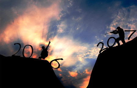 Silhouette of a young man on skates and arrow with a gun during the celebration of the new 2017.の写真素材