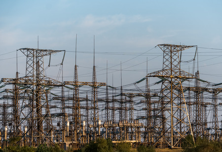 distribution electric substation with power lines and transformers, at sunset.
