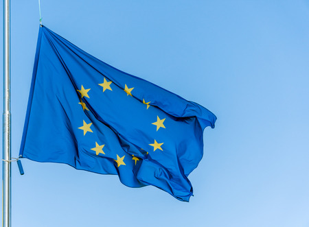 European Union flag flying in front of bright blue sky