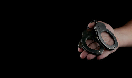 steel handcuffs of police special equipment, fetters on a black backgroundの写真素材