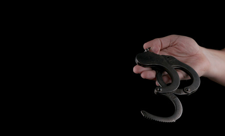 steel handcuffs of police special equipment, fetters on a black backgroundの写真素材
