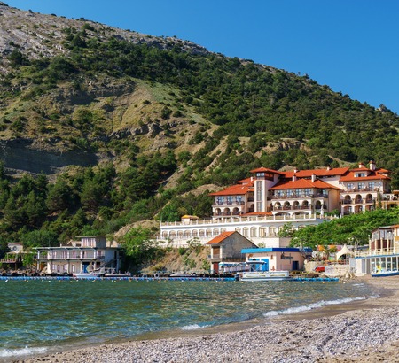 beautiful hotel on the coast in front of the mountain.の写真素材
