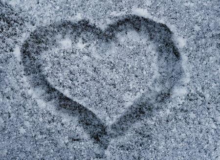 The shape of heart on the snow. Closeup shot. Hand drawn heart shape in the fresh snowの写真素材