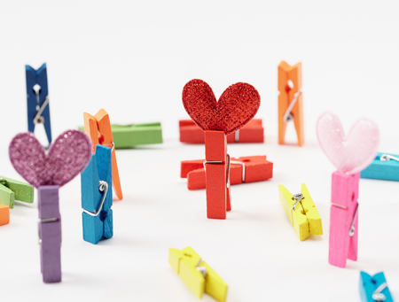 Colourful wooden clothespin with hearts isolated on white background close up.の写真素材