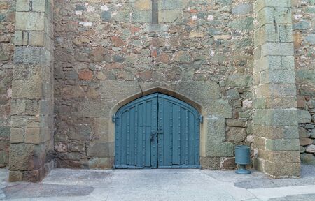 Solid castle wooden door arch door and stone wall close upの写真素材