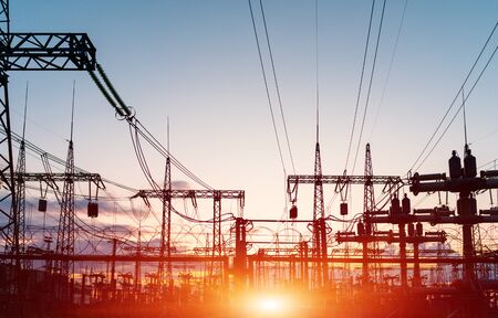 The silhouette of the evening electricity transmission pylon. Power transmission from a power plant...