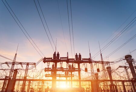 High-voltage power lines at sunset or sunrise. High voltage electric transmission tower.