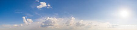 Wide sky panorama with scattered cumulus clouds.