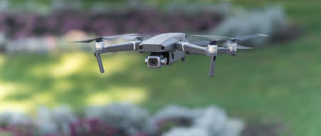 Drone flying during the day in field of flowers.