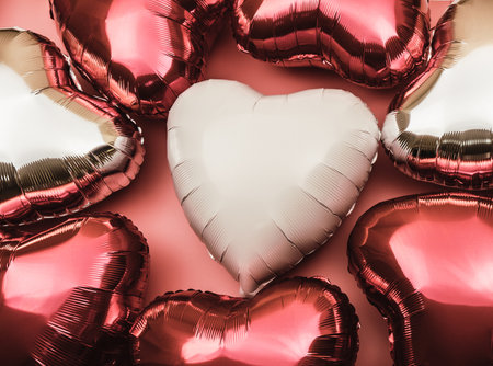 Heart-shaped balloon as a symbol of Valentine's Day. Background of foil balloons in the shape of a heart in shades of red.の写真素材