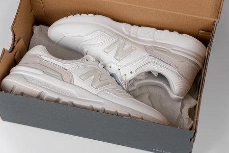 Kiev, Ukraine - January 03, 2021: White women's casual sneakers from the New Balance brand in an original box on a light background.のeditorial素材