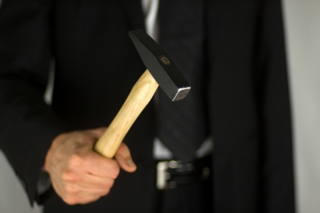 Isolated businessman holding a hammer.の写真素材