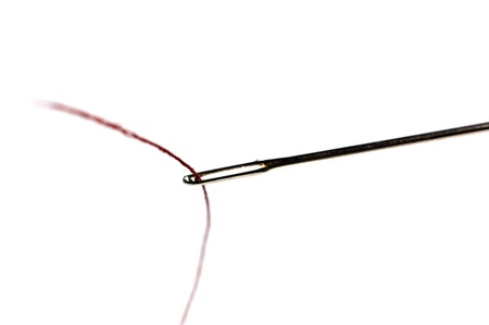 Needle with a red thread isolated on a white background 