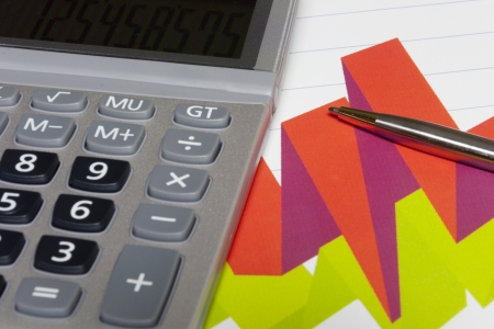 Pen and calculator on finance graphics.の写真素材