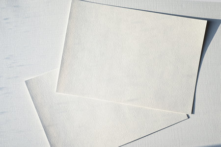 Hand holding a blank a4 size paper isolated on grey backgroundの写真素材