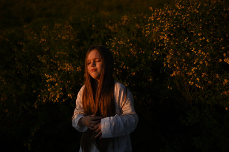 Girl in a field with yellow flowers at sunset. selective focus.の写真素材