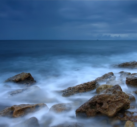 Beautiful rocky sea beach at the sunsetの写真素材