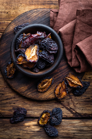 Prune, dried plums fruits on dark rustic wooden backgroundの写真素材