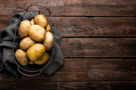 Raw potato on wooden background, top viewの写真素材