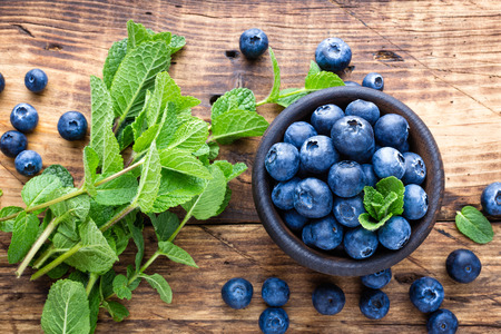 Fresh blueberries in bowl on wooden tableの写真素材