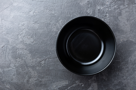 Empty black soup plate on dark grey background, top viewの写真素材