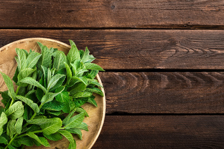 Fresh mint leaves on wooden rustic table, top viewの写真素材