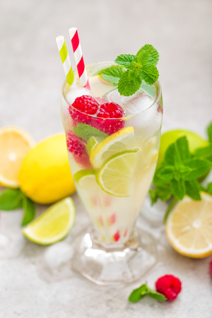 Lemon mojito cocktail with lime, mint and raspberry, cold drink with ice.の写真素材