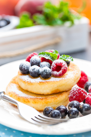 Cottage cheese pancakes, syrniki, curd fritters with berriesの写真素材