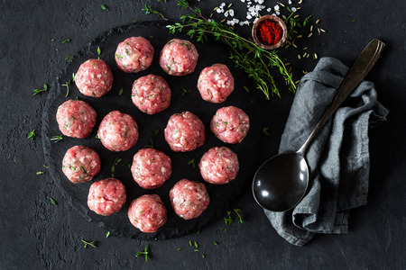 Raw meatballs on dark background, top viewの写真素材