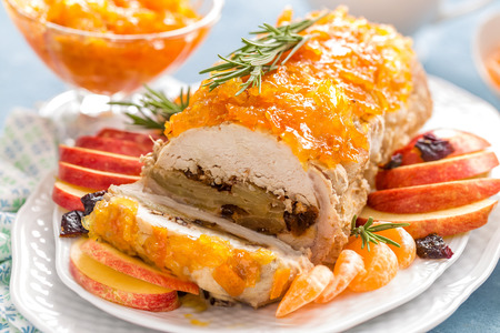 Baked meatloaf stuffed with apples and plums, decorated tangerine confiture. Christmas menuの写真素材