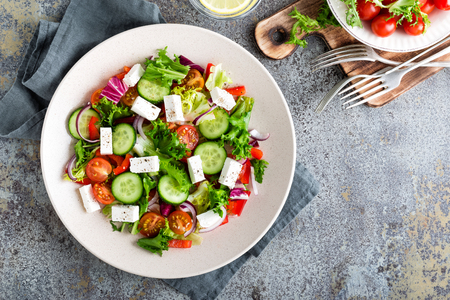Fresh vegetable salad with feta cheese, fresh lettuce, cherry tomatoes, red onion and pepperの写真素材