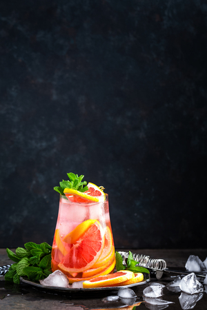 Grapefruit and fresh mint cocktail with juice, cold summer citrus refreshing drink or beverage with iceの写真素材
