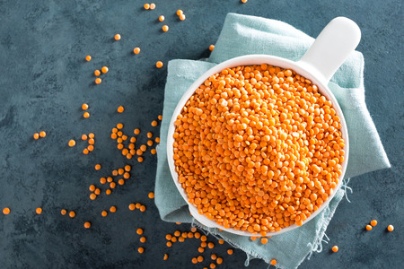 Raw lentil in bowl on table. Fresh lentils. Vegetarian food. Top view の写真素材