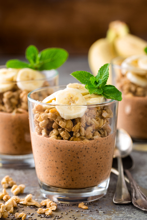 Layered chocolate chia pudding parfait with banana, granola and yogurt, dessertの写真素材