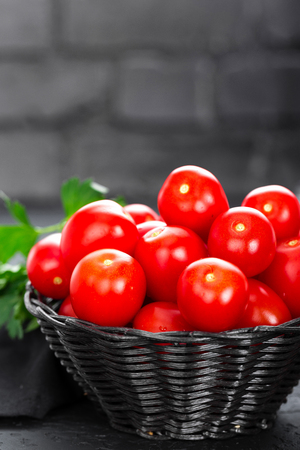 Tomatoes. Fresh tomatoes in basket on tableの写真素材
